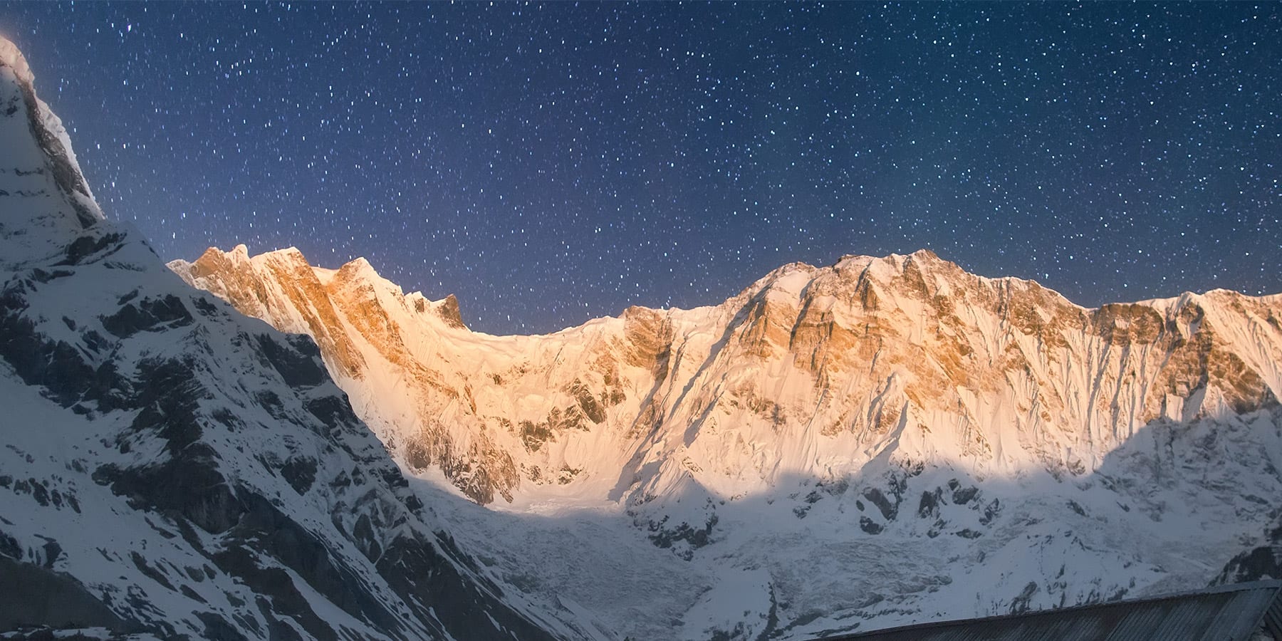 Evening scene: starry sky framed by snowy Annapurna mountain peaks