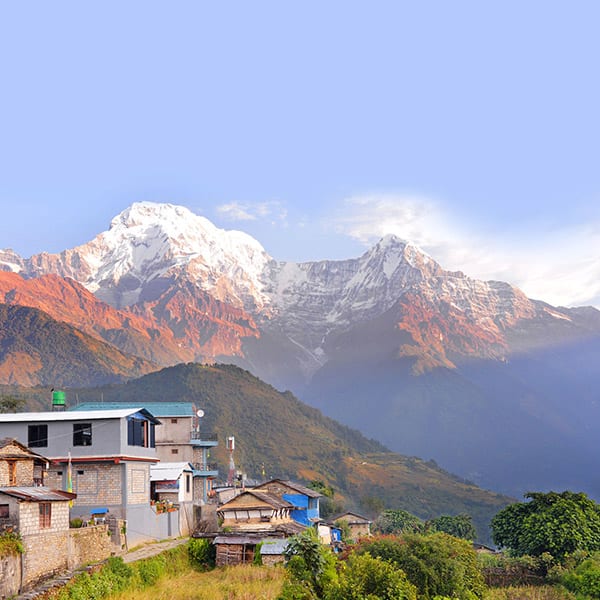 Rural village perched on an outlook with a view of the Annapurna mountains at sunset