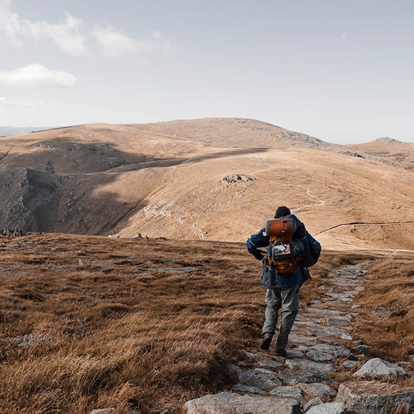 Lone trekker following a stone path through Mt Kosciuszko National Park