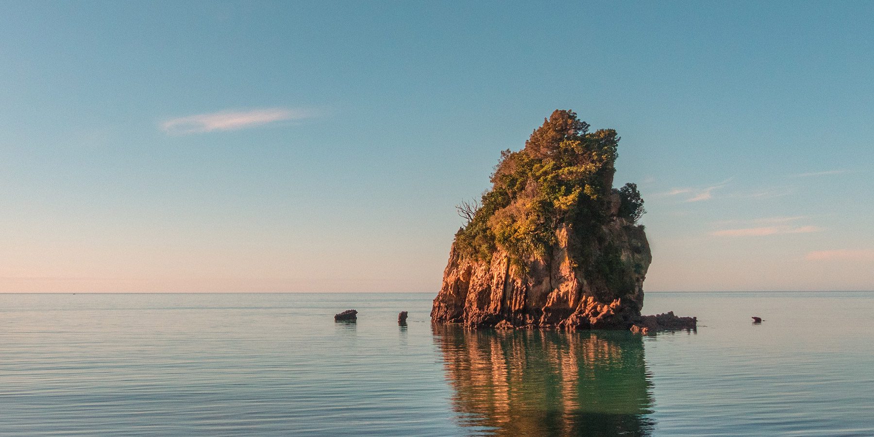 Tiny, lone island emerging from the water. Abel Tasman, New Zealand