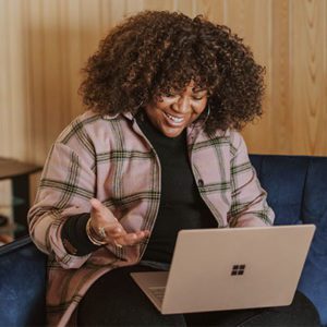 Smiling woman sitting on a couch with a laptop