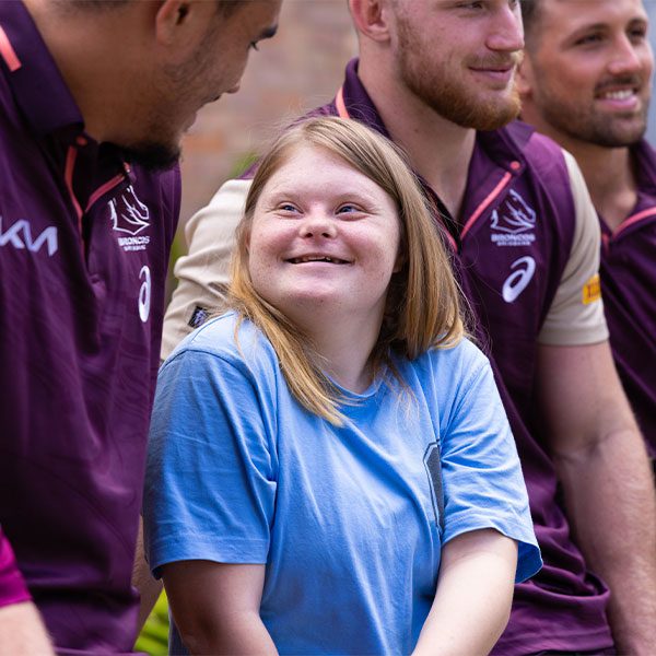 image of girl and rugby players from Down Syndrome QLD