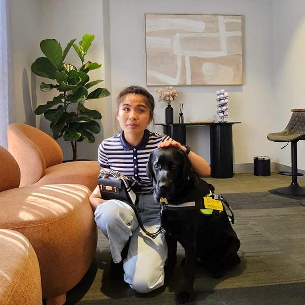 Youth Program alumni Anna kneels beside her Seeing Eye Dog Kylie.