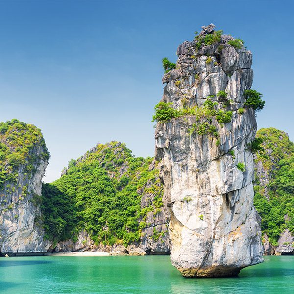 Beautiful rock formations rising dramatically out of azure waters of Halong Bay, Vietnam.